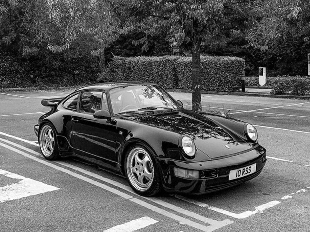 Porsche 911 noire garée, la voiture réelle de référence